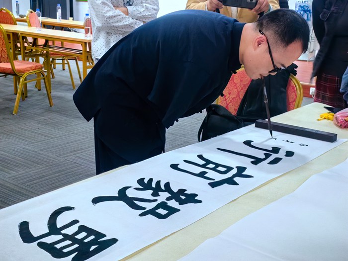 中国肢协口足书画工作委员会秘书长、书法家何子龙书法现场.jpg